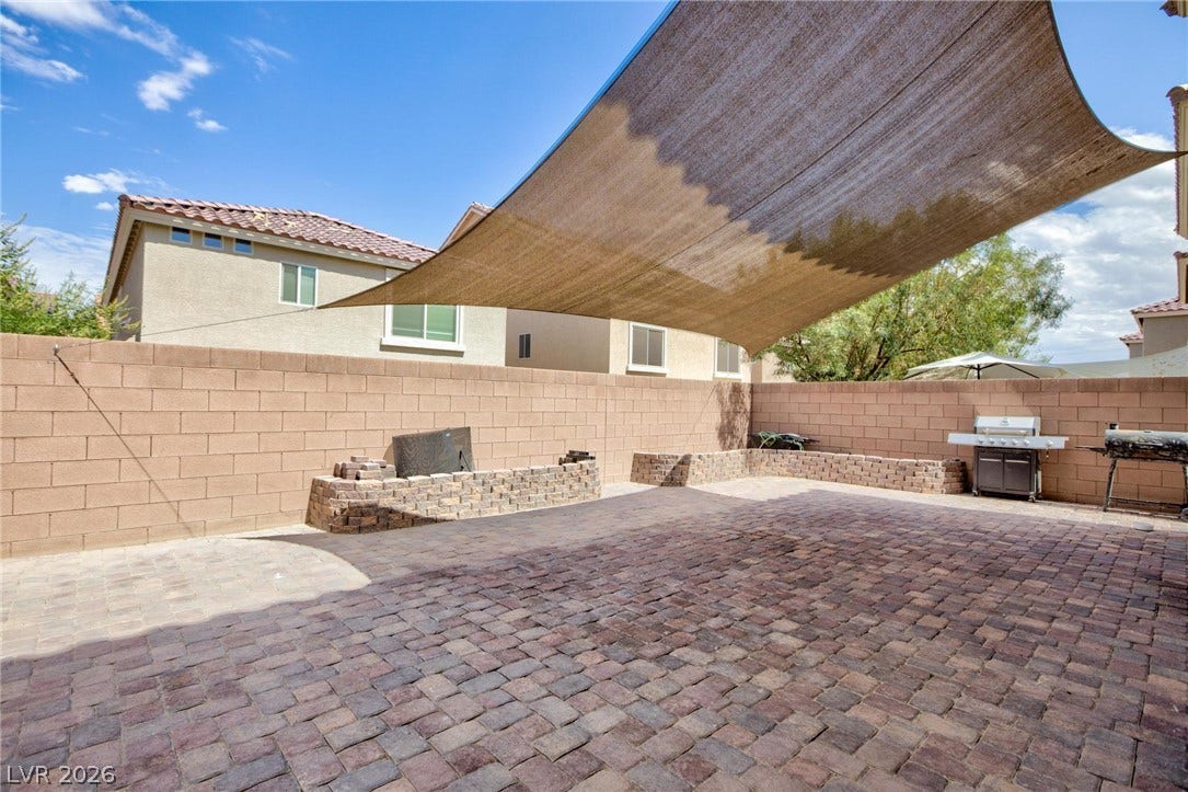 9804 Kodiak Island Court, Las Vegas, NV 89141 A spacious brick paver patio features a large overhead shade sail and masonry privacy walls.