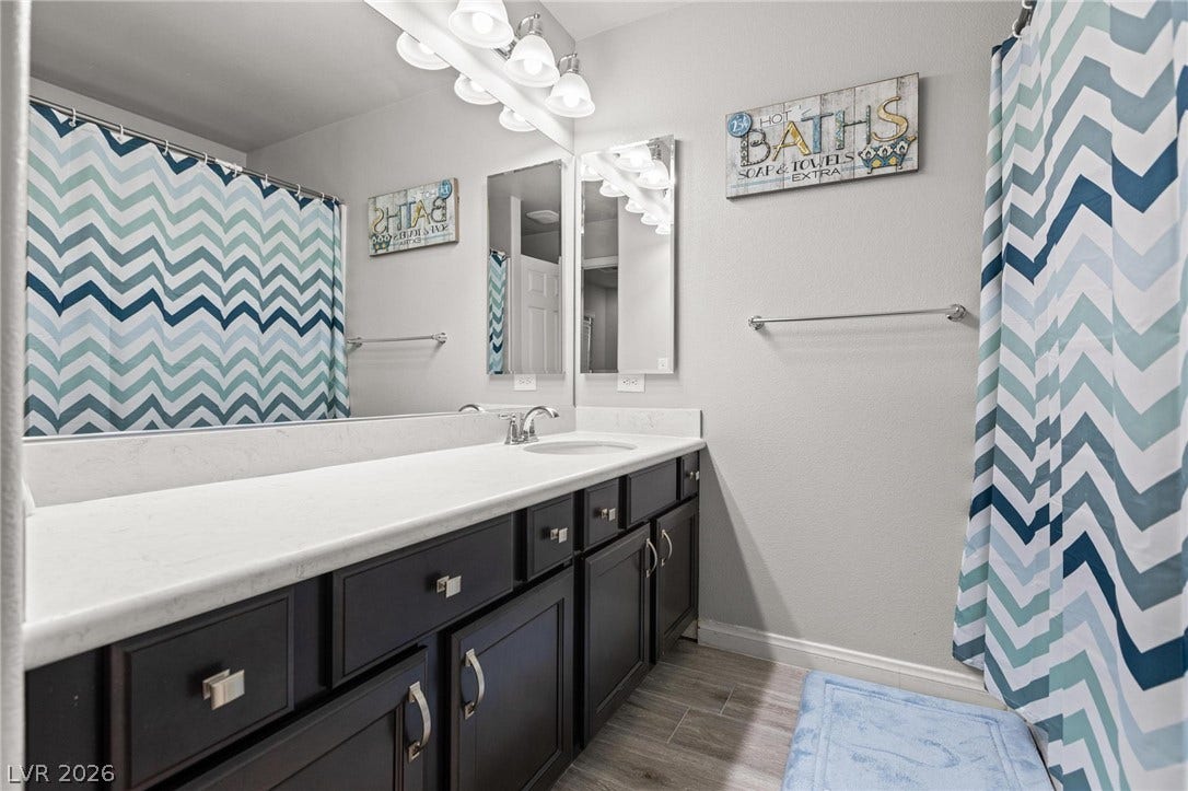 9804 Kodiak Island Court, Las Vegas, NV 89141 An updated vanity featuring stone countertops and clean lines anchors this modern bathroom.