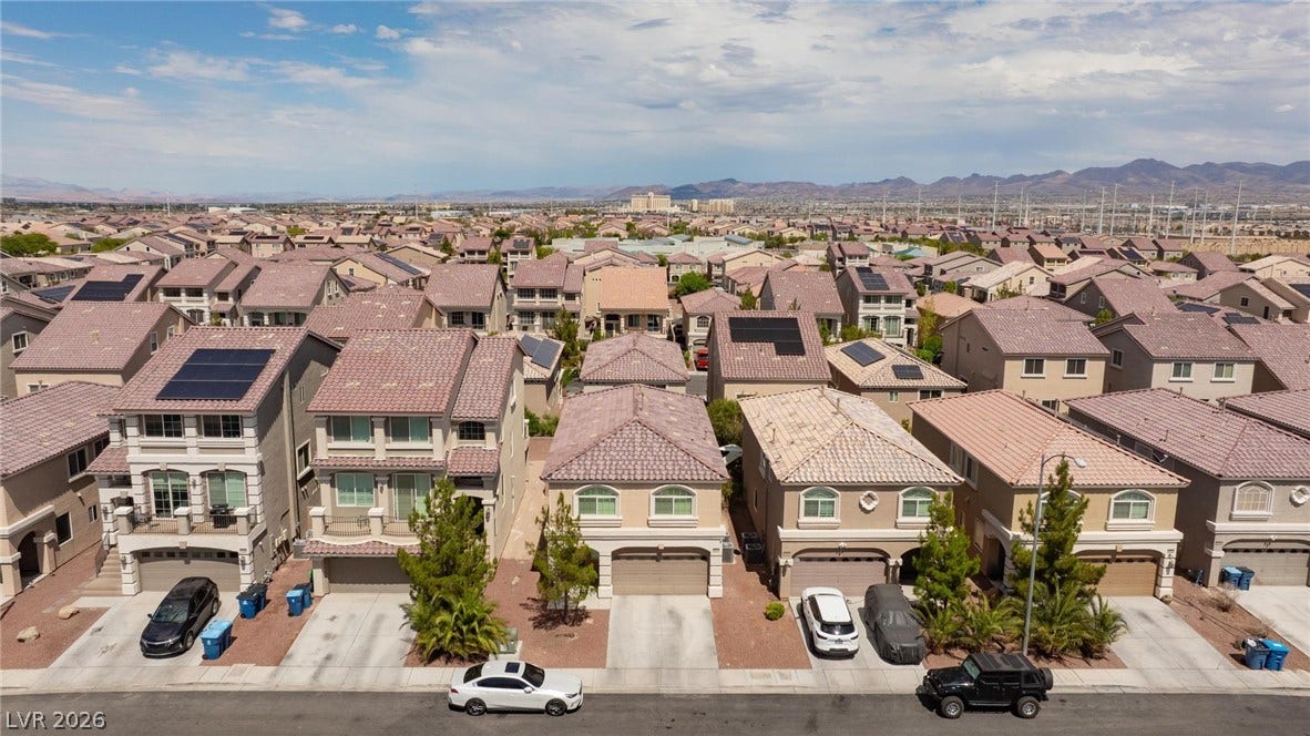 9804 Kodiak Island Court, Las Vegas, NV 89141 A quiet suburban street of tile-roofed residences sits against a backdrop of distant mountains.