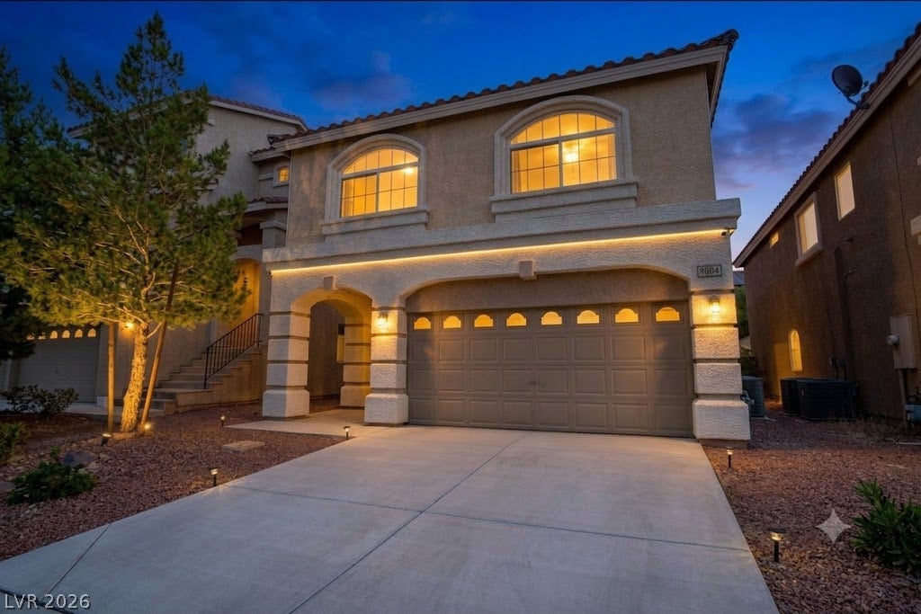 9804 Kodiak Island Court, Las Vegas, NV 89141 Stucco arches and Spanish tile roofing define this multi-level home with a concrete driveway.