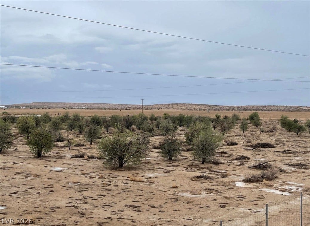 Panoramic desert vistas stretch across this expansive property under a wide open sky.