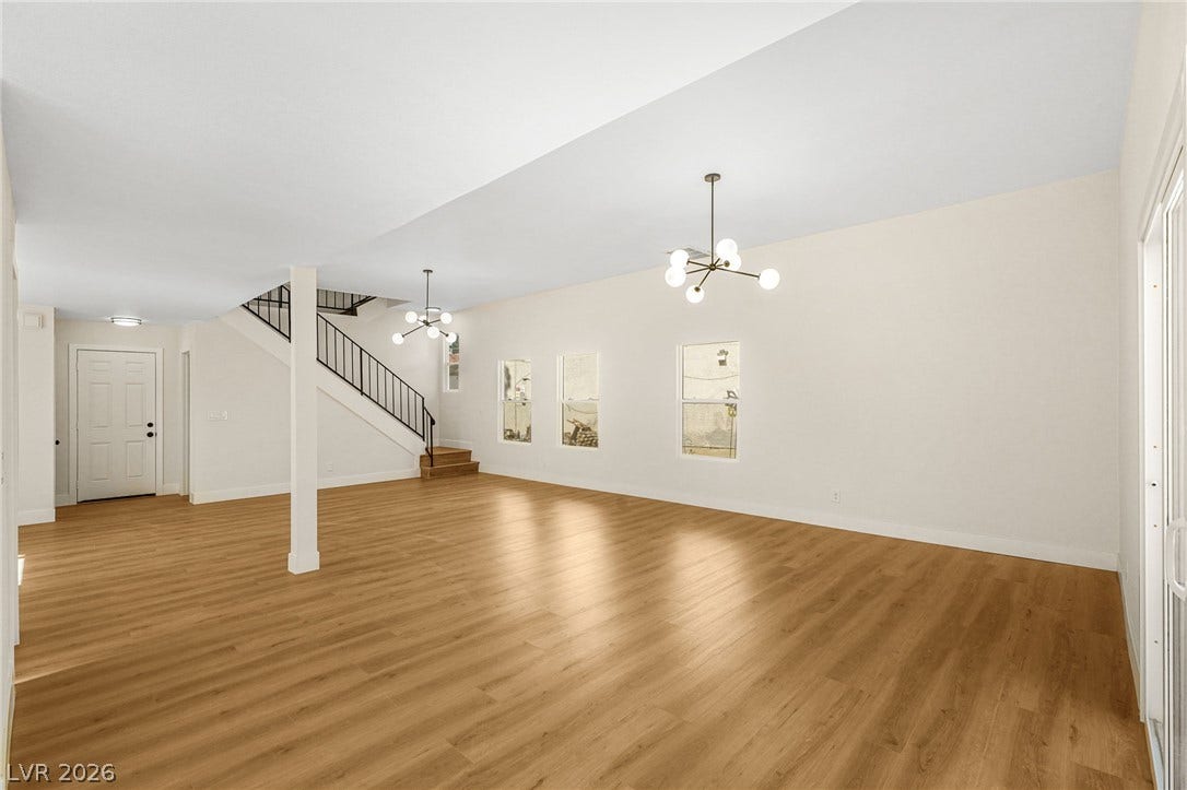 Gleaming wood floors and architectural lighting define this airy, open-concept living area.