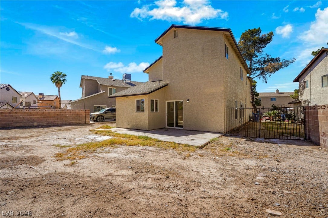 An open backyard canvas awaits personal touches behind this multi-level stucco home.