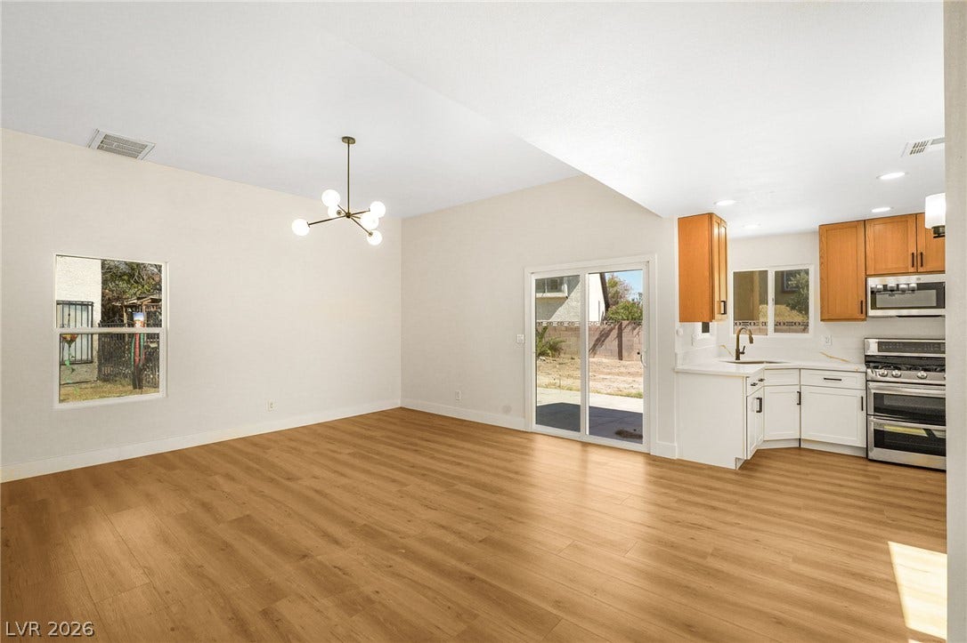 Gleaming wood floors connect the open dining area to a modern, fully equipped kitchen.