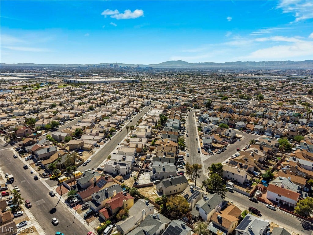 Vast neighborhood panoramas stretch toward the distant mountain range under clear blue skies.