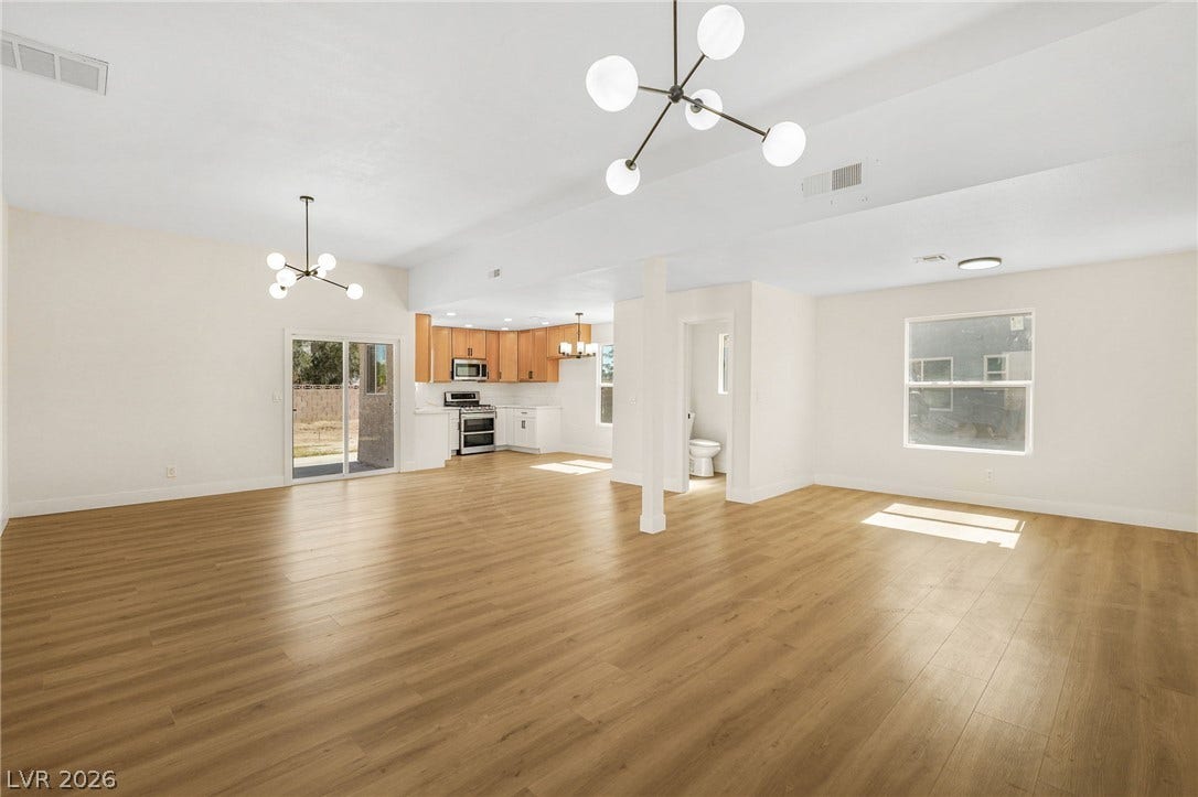 Warm wood flooring and an airy open floorplan flow seamlessly into the kitchen area.