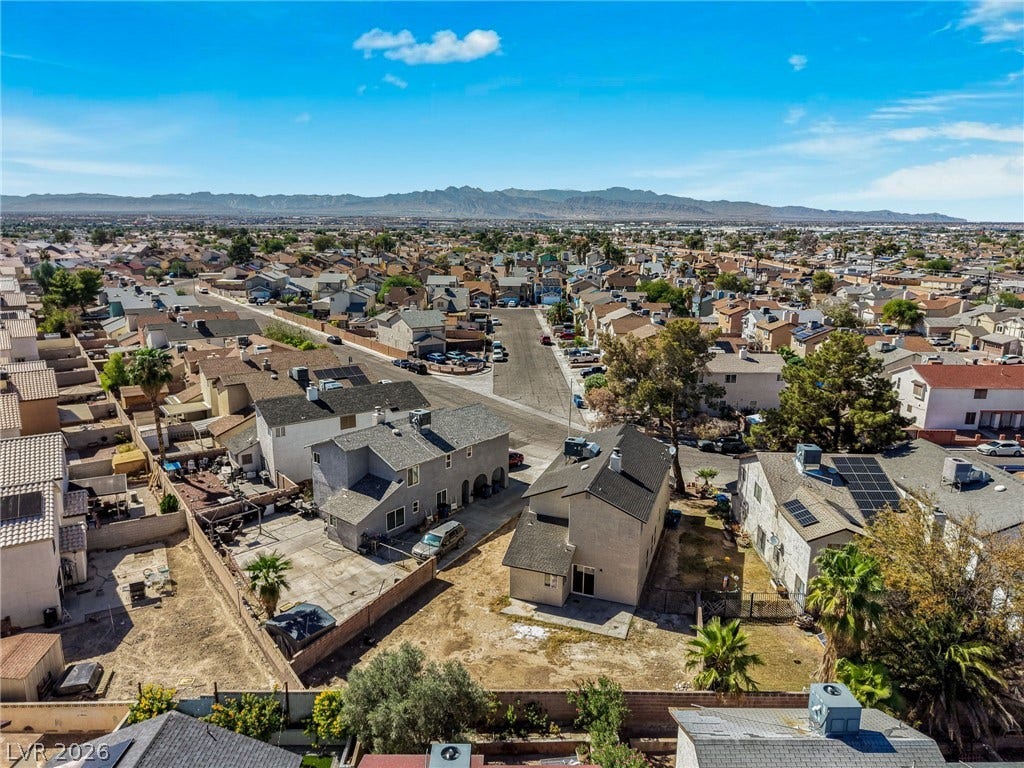 Distant mountain ranges border this expansive suburban neighborhood under clear blue skies.