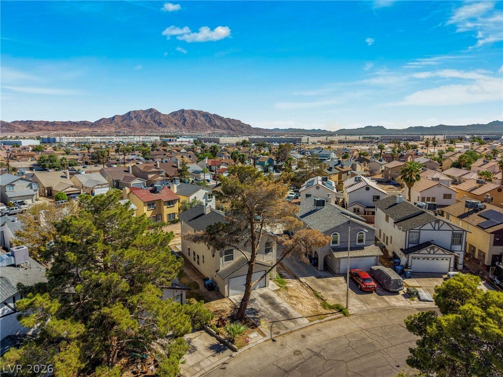 Distant mountain ranges rise behind this quiet neighborhood street lined with classic suburban homes.