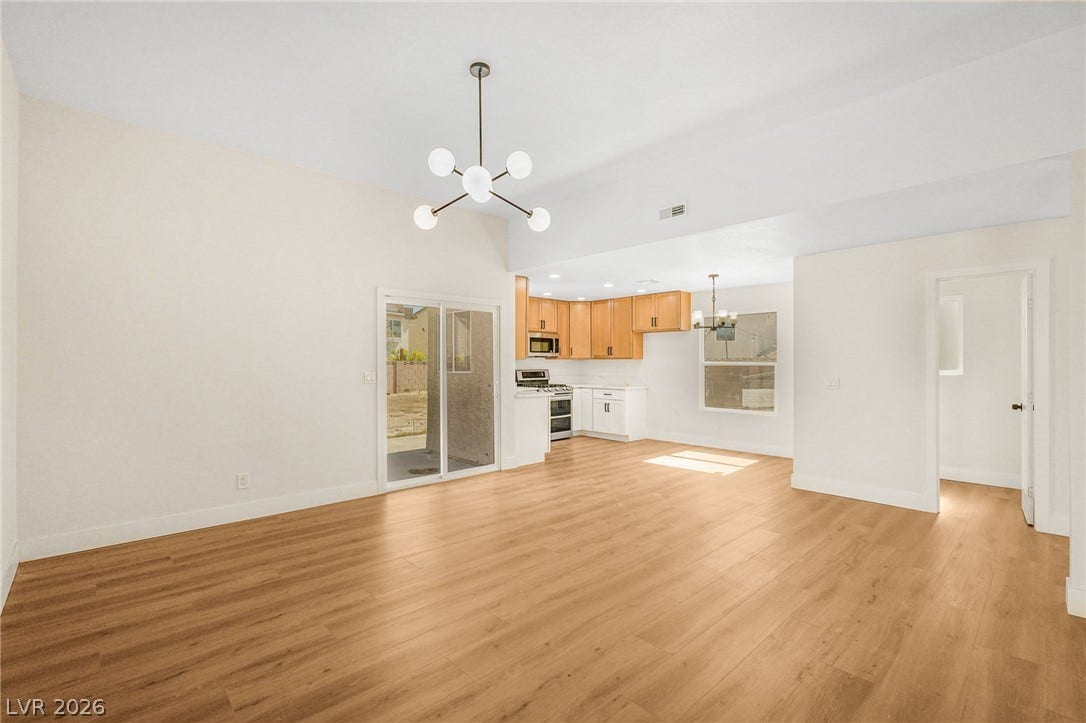 Smooth wood floors flow seamlessly beneath a vaulted ceiling in this open-concept main level.
