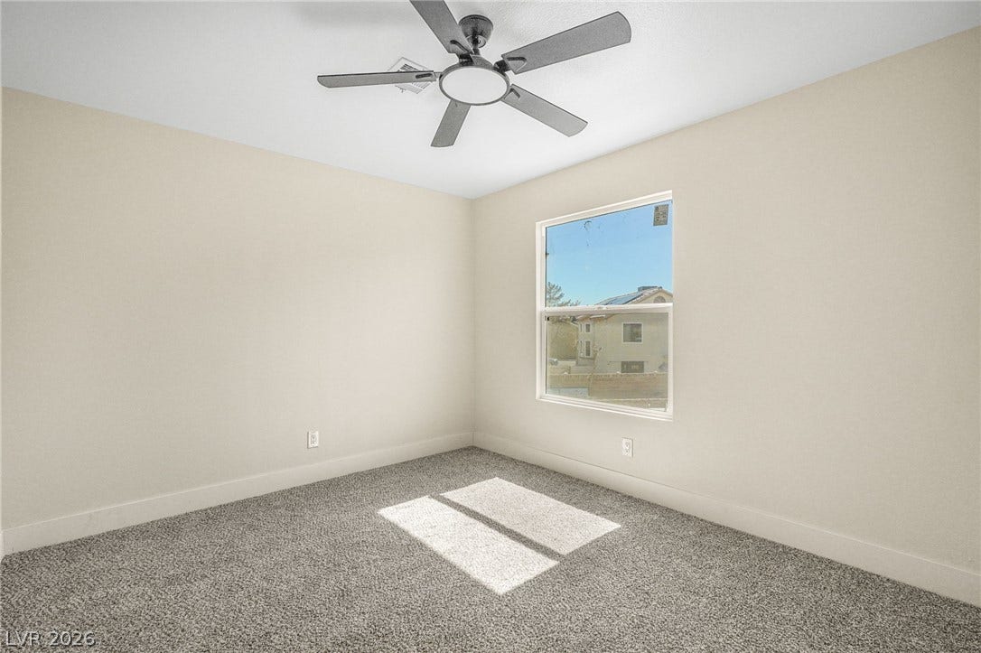 Soft carpeting pairs with a bright window overlooking the neighborhood in this comfortable space.