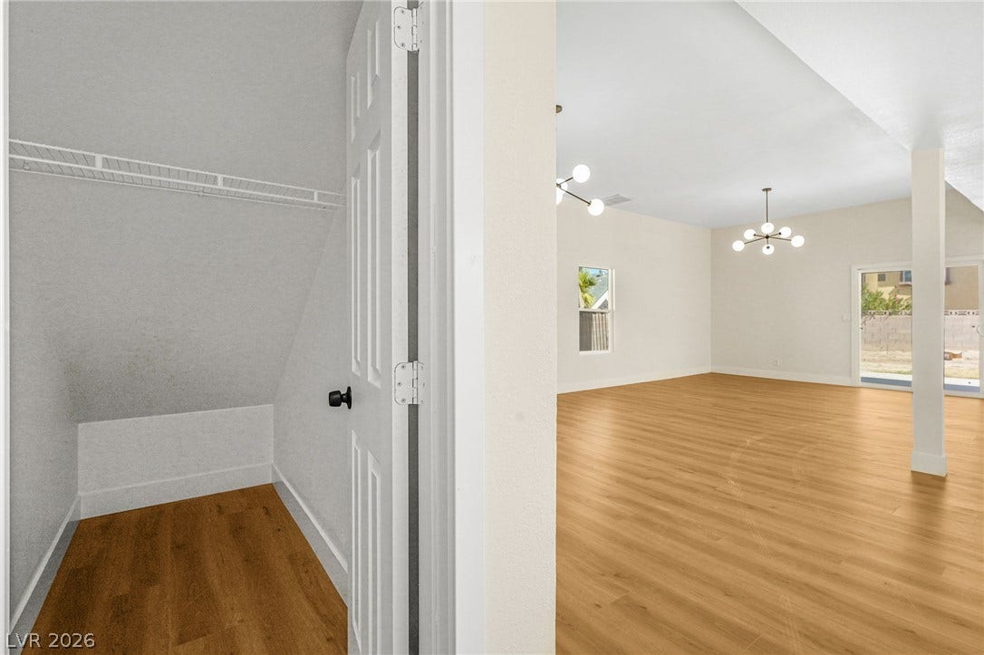 Smooth wood floors flow from a storage closet under the stairs into an open living room.