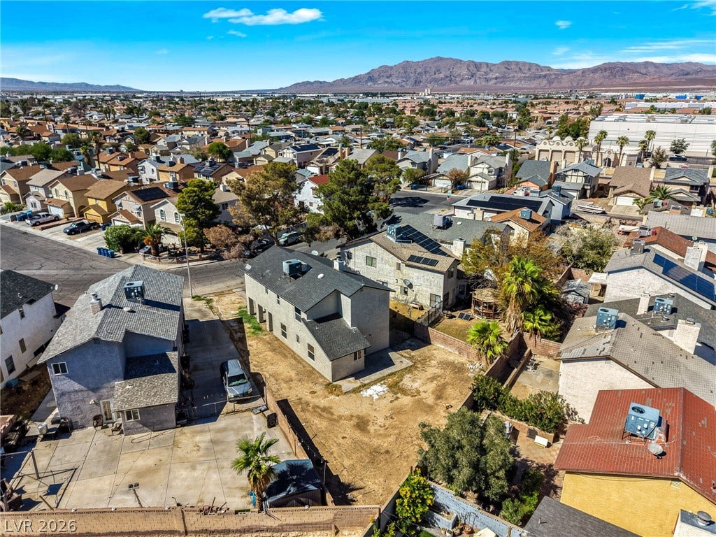 A wide neighborhood perspective showcases desert vistas and distant mountain ranges under clear blue skies.