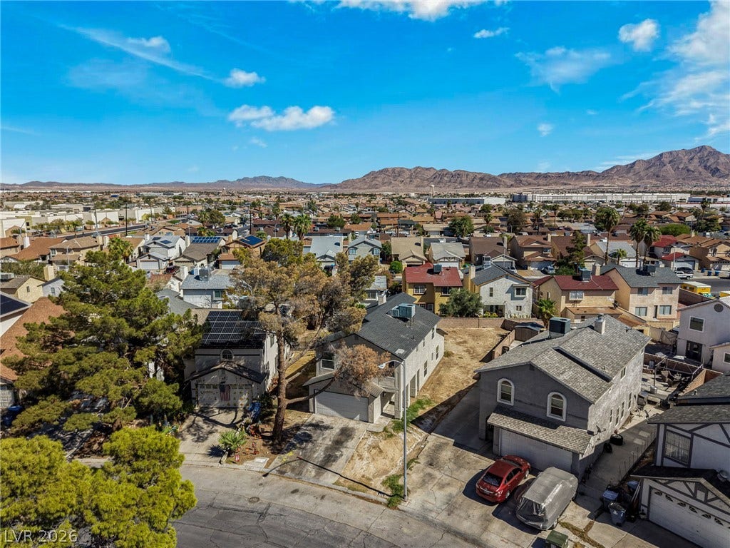 An elevated perspective showcases the surrounding neighborhood nestled against a scenic mountain backdrop.