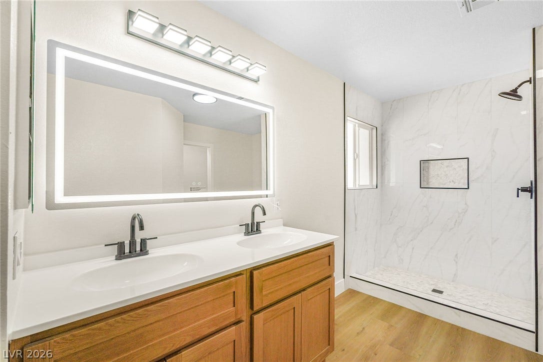 A spacious double vanity and a beautifully tiled walk-in shower highlight this modern bathroom.