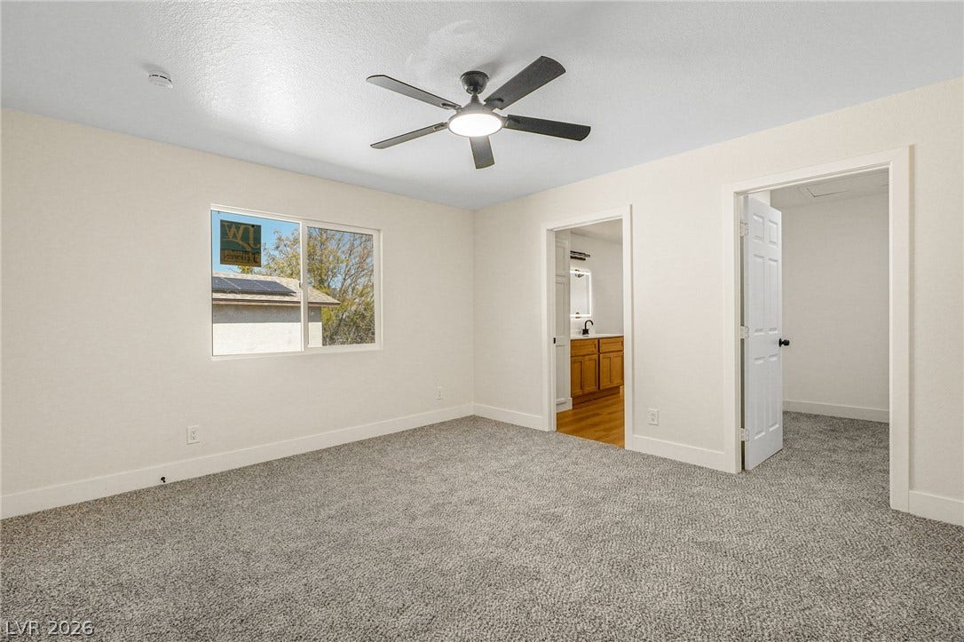 Soft carpeting underfoot anchors this quiet space featuring dual doorways and natural window light.