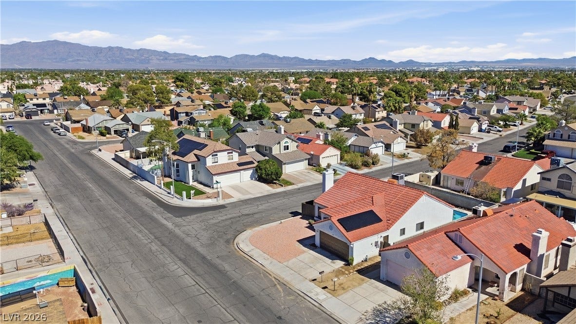 1013 Greystone Drive, Las Vegas, NV 89108 A quiet residential neighborhood of modern homes stretches toward a dramatic mountain backdrop.