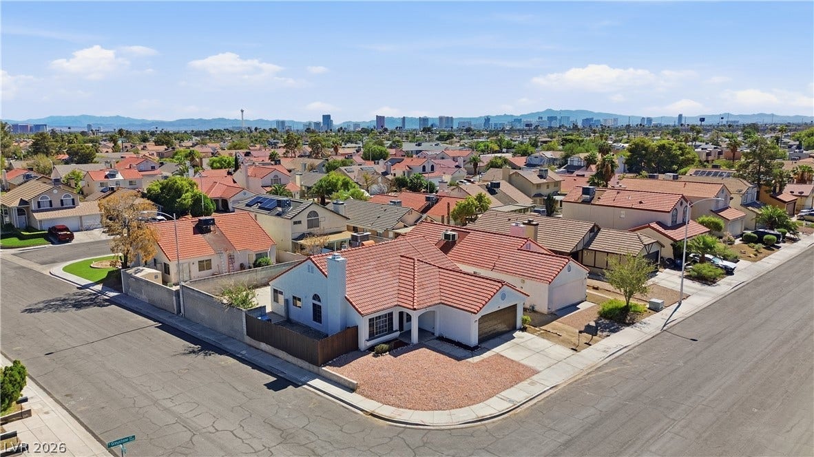 1013 Greystone Drive, Las Vegas, NV 89108 Distant city skyline views frame this corner lot home topped by a tile roof.