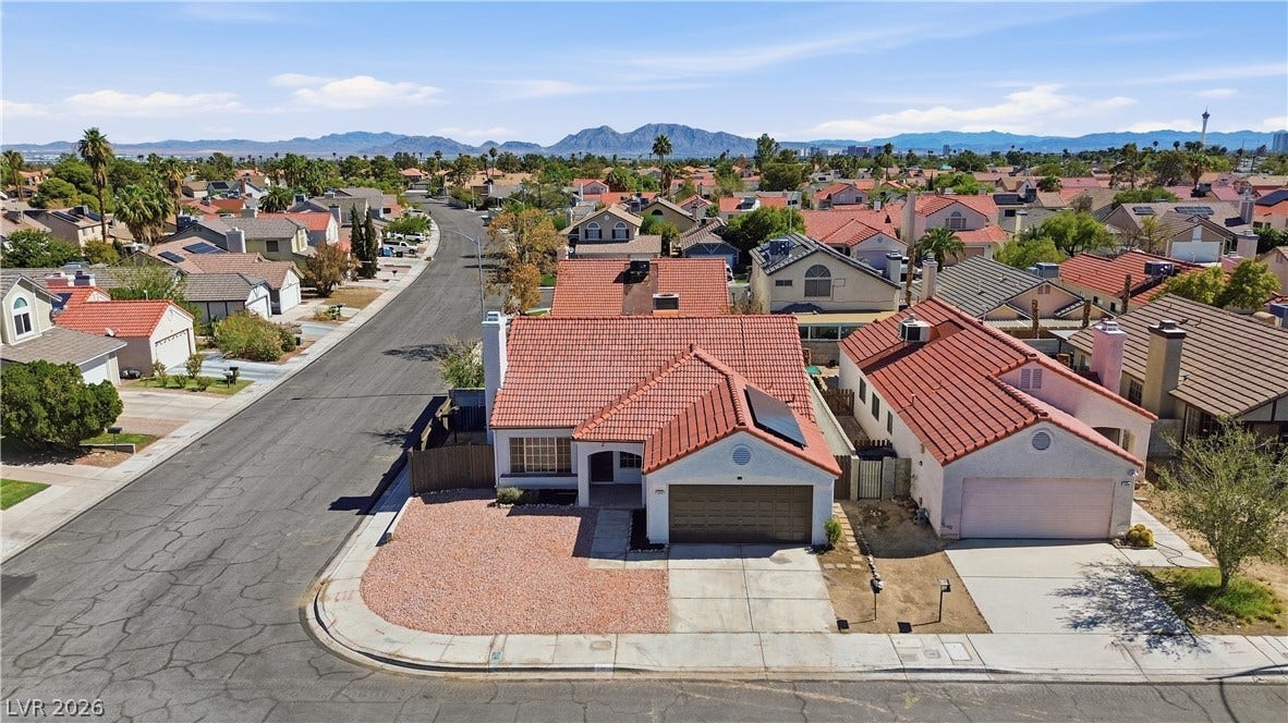 1013 Greystone Drive, Las Vegas, NV 89108 Spanish tile roofing and desert landscaping accent this suburban home framed by distant mountains.