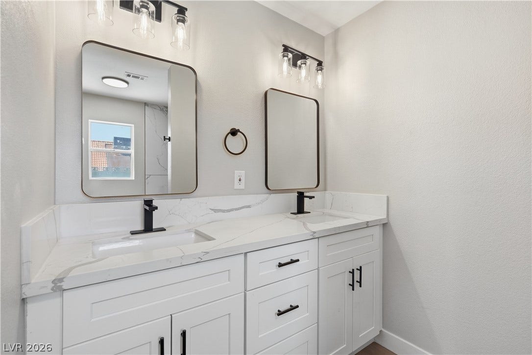 1013 Greystone Drive, Las Vegas, NV 89108 Clean lines and a stone-topped double vanity define this sleek contemporary bathroom design.