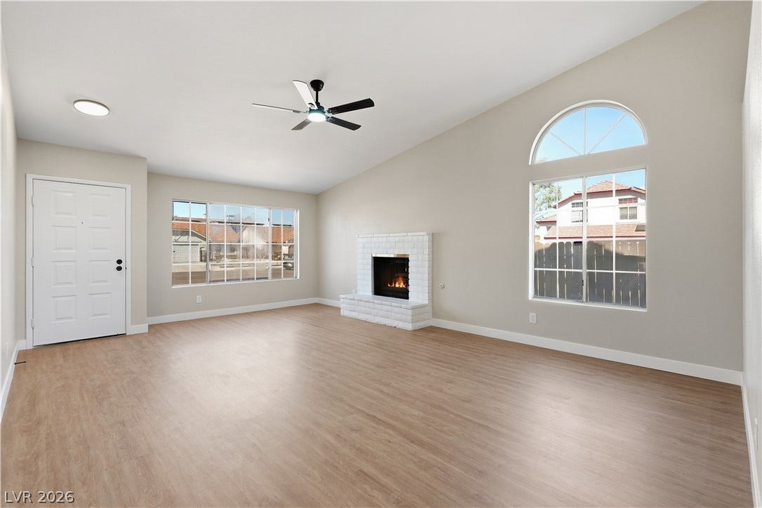1013 Greystone Drive, Las Vegas, NV 89108 Vaulted ceilings and a white brick fireplace anchor this welcoming open living space.