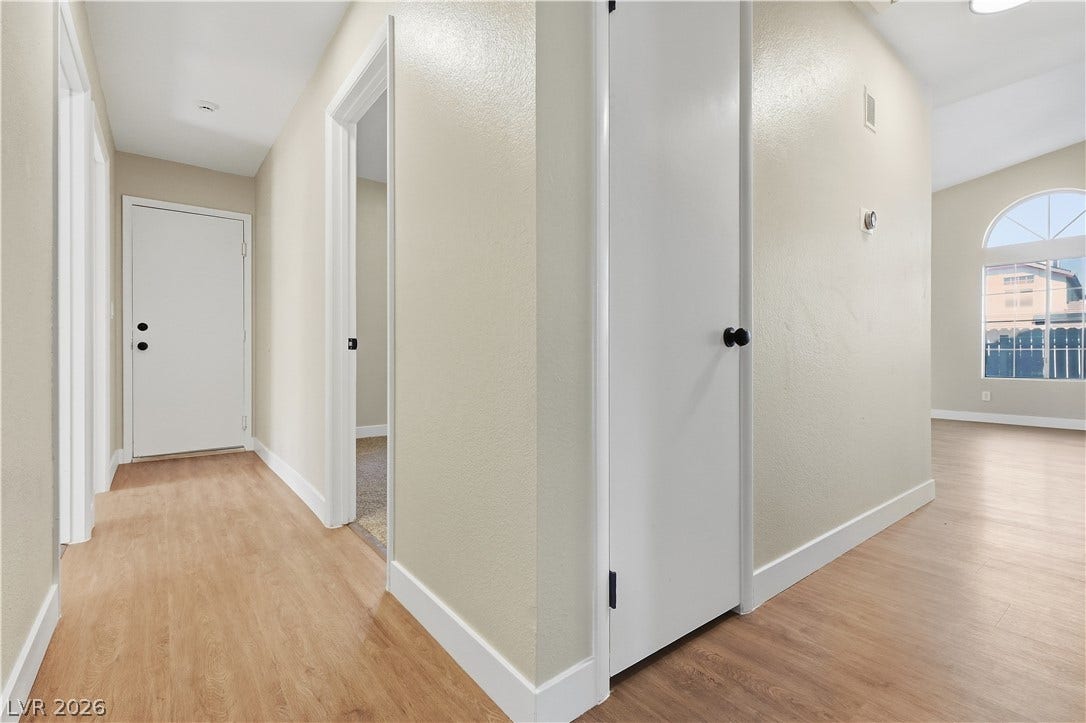 1013 Greystone Drive, Las Vegas, NV 89108 Smooth wood-style flooring and arched windows enhance this bright, open hallway and living layout.