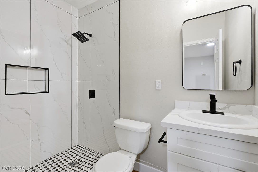 1013 Greystone Drive, Las Vegas, NV 89108 A contemporary walk-in shower with stone pattern tile highlights this updated bathroom space.