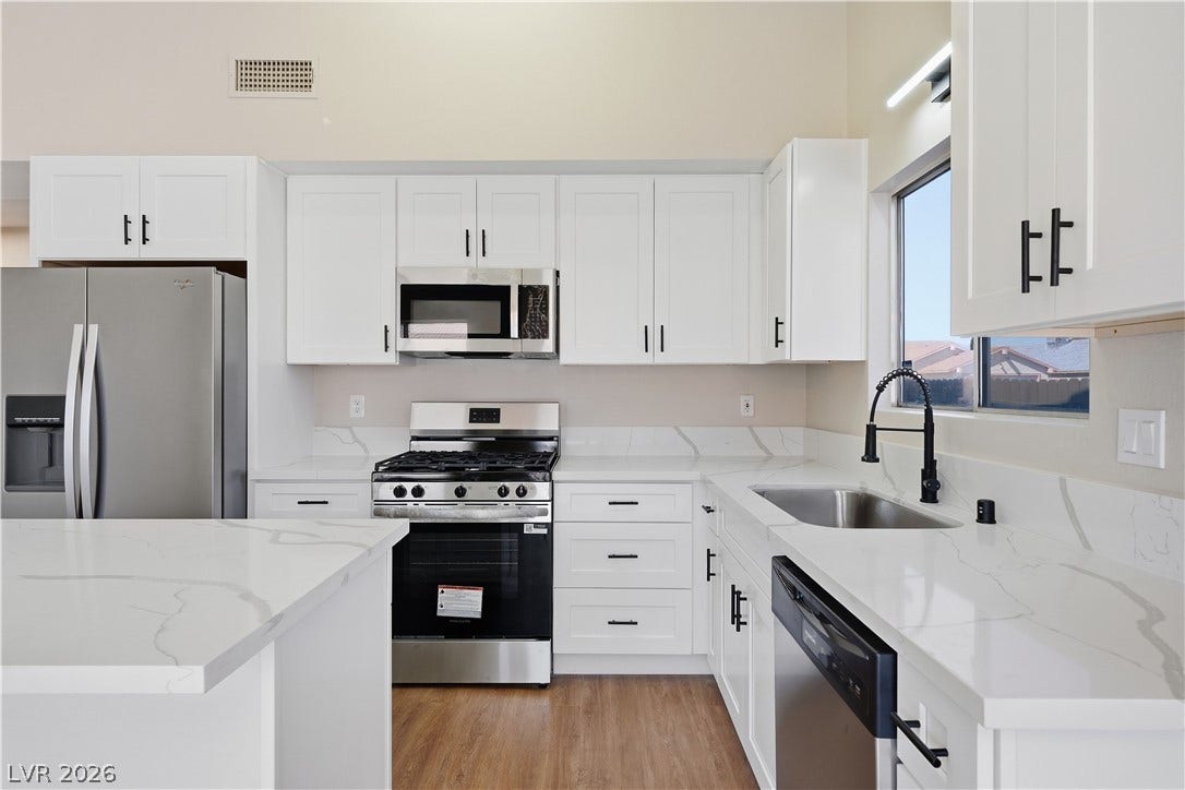1013 Greystone Drive, Las Vegas, NV 89108 Gleaming stone countertops and crisp cabinetry anchor this updated, modern kitchen space.