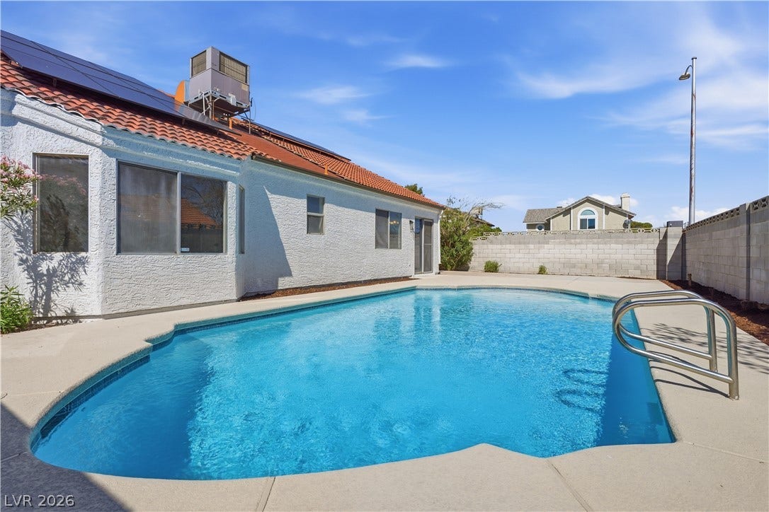 1013 Greystone Drive, Las Vegas, NV 89108 An inviting backyard oasis features a clean, sparkling swimming pool surrounded by concrete decking.