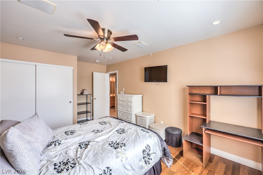 Gleaming wood-laminate floors and recessed lighting anchor this comfortable bedroom retreat.