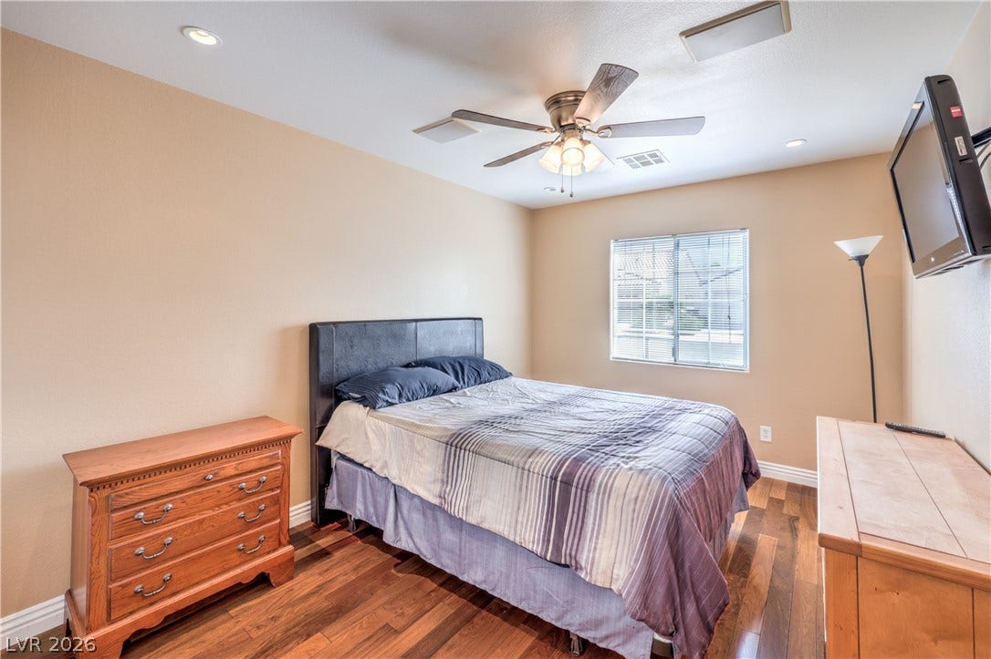 Gleaming wood-laminate floors and a bright window elevate this comfortable private bedroom.