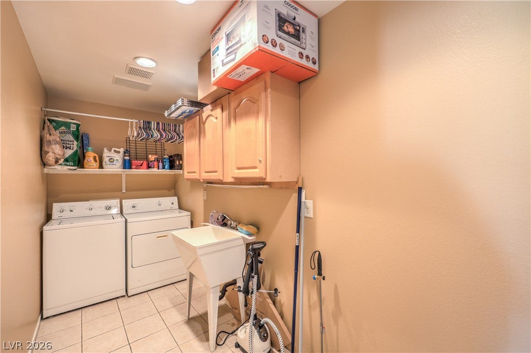 Functional tile flooring and abundant cabinetry define this practical utility space.
