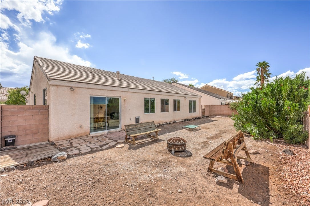 A spacious desert backyard offers a tiled patio area and privacy block fencing.