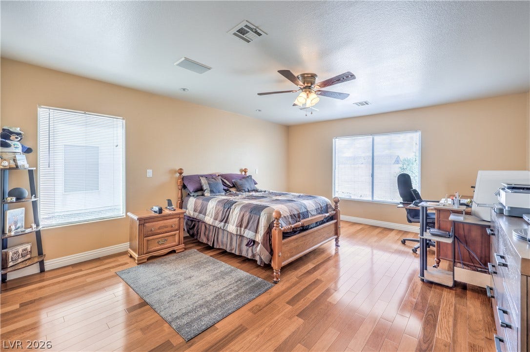 Warm wood-laminate flooring and natural light from large windows define this spacious private retreat.