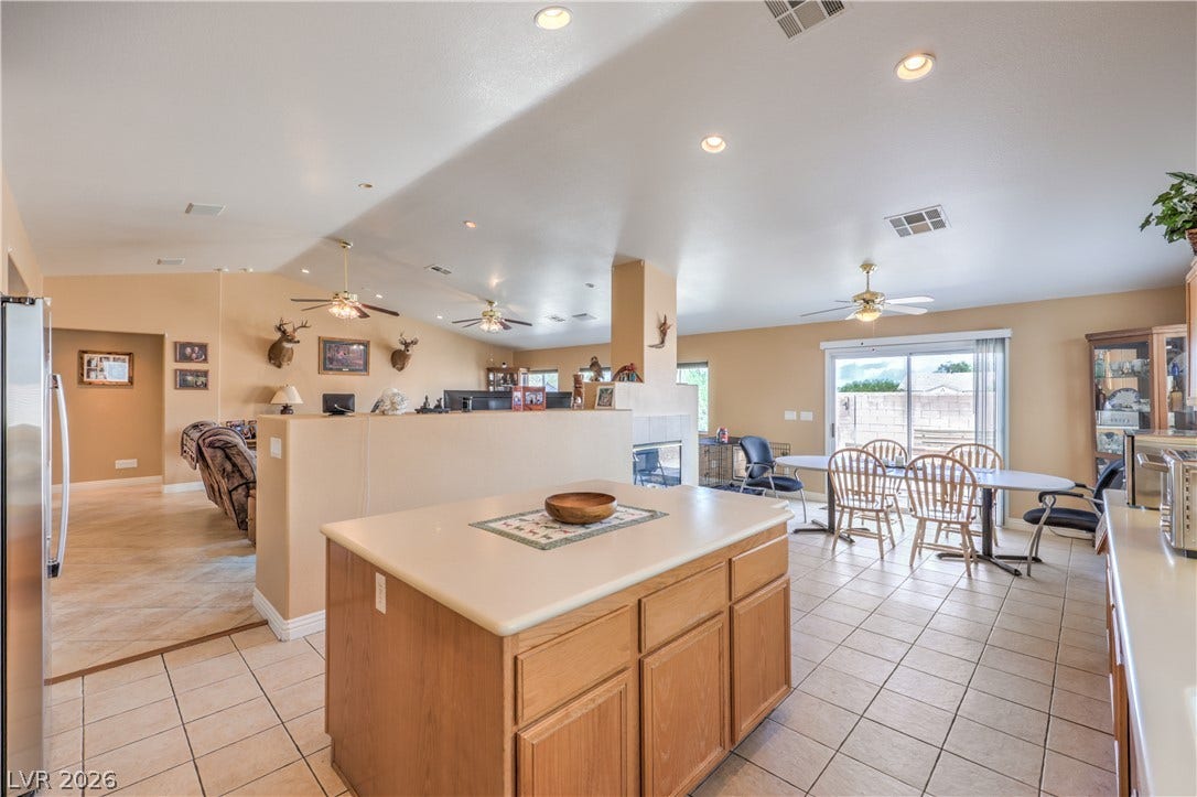Tile flooring and sliding glass doors highlight this expansive open kitchen and dining area.