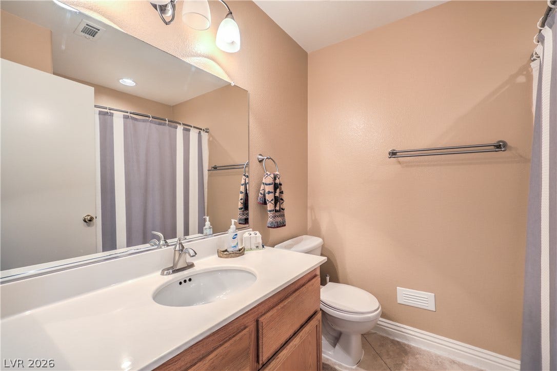 Functional vanity storage paired with tile flooring defines this tidy guest bathroom.