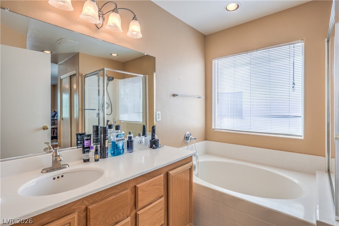 An inviting bathroom features a deep soaking tub positioned beneath a large window.