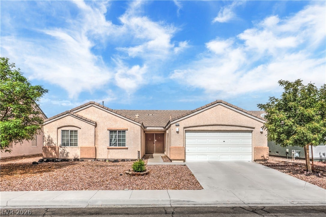 Classic desert landscaping accents this single-story home featuring a clean stucco exterior and concrete driveway.
