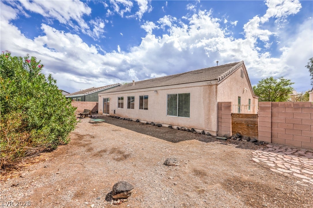 A spacious backyard area borders the stucco exterior.