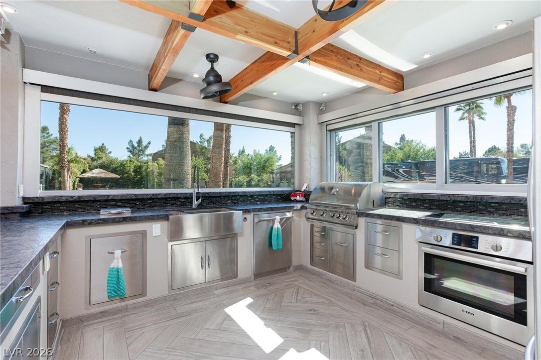 8175 Arville Street, #142, Las Vegas, NV 89139 Exposed wood beams and generous glass windows frame this fully equipped outdoor kitchen workspace.