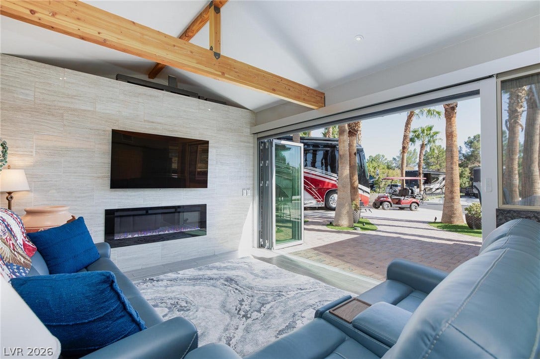 8175 Arville Street, #142, Las Vegas, NV 89139 Exposed ceiling beams accent this modern living area featuring folding glass doors that open outside.