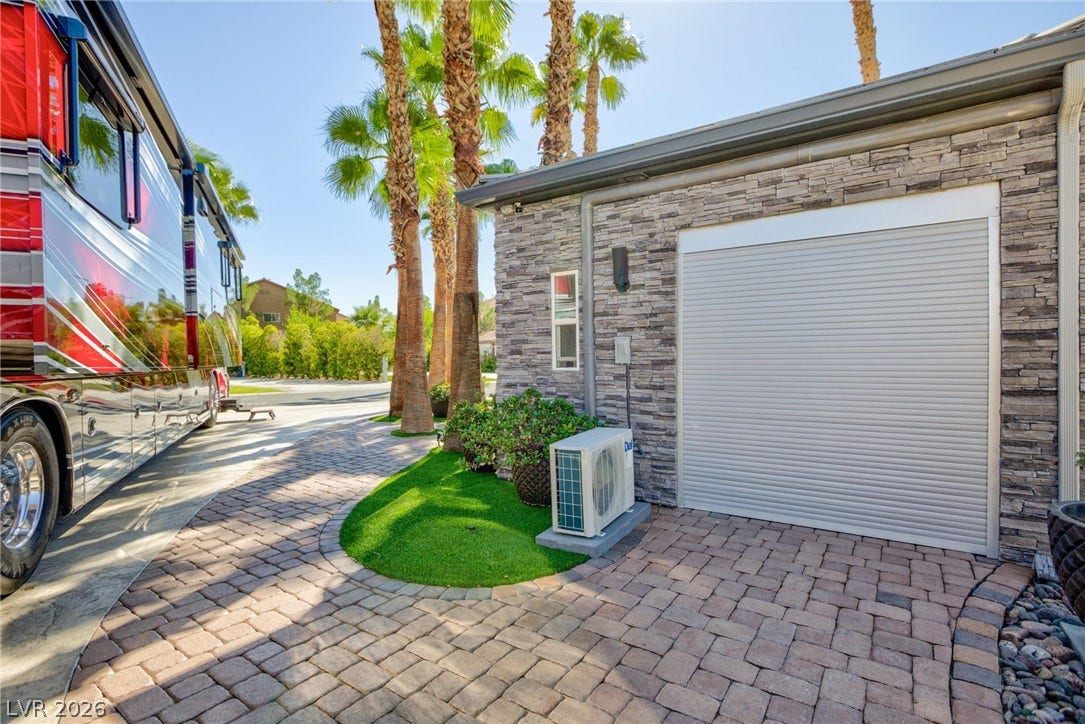 8175 Arville Street, #142, Las Vegas, NV 89139 A stone-accented exterior wall borders a paved drive surrounded by towering palm trees.