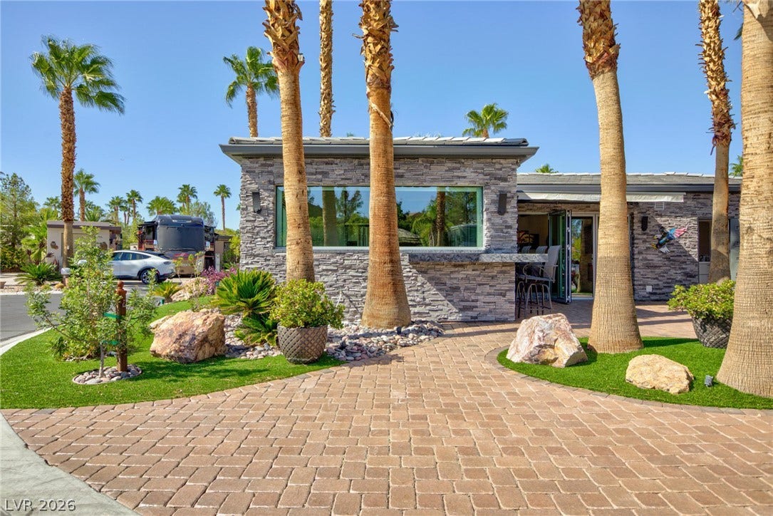 8175 Arville Street, #142, Las Vegas, NV 89139 Towering palm trees flank the stone-clad exterior and paved courtyard of this modern desert residence.