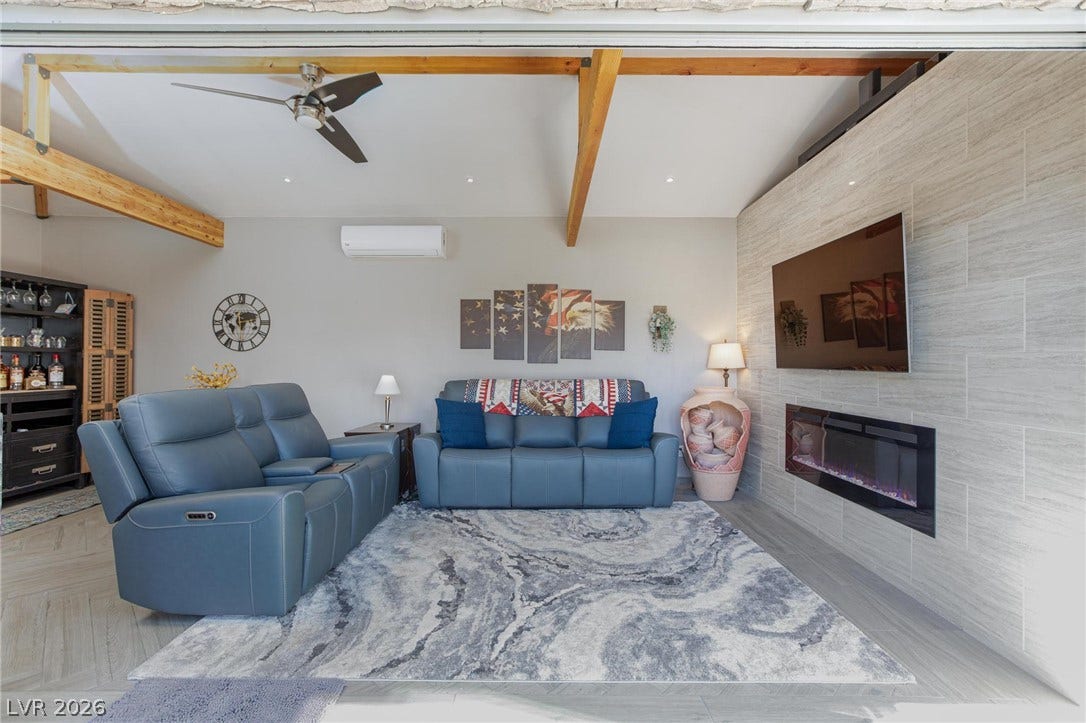 8175 Arville Street, #142, Las Vegas, NV 89139 Exposed wood beams and a modern fireplace elevate this inviting living space.