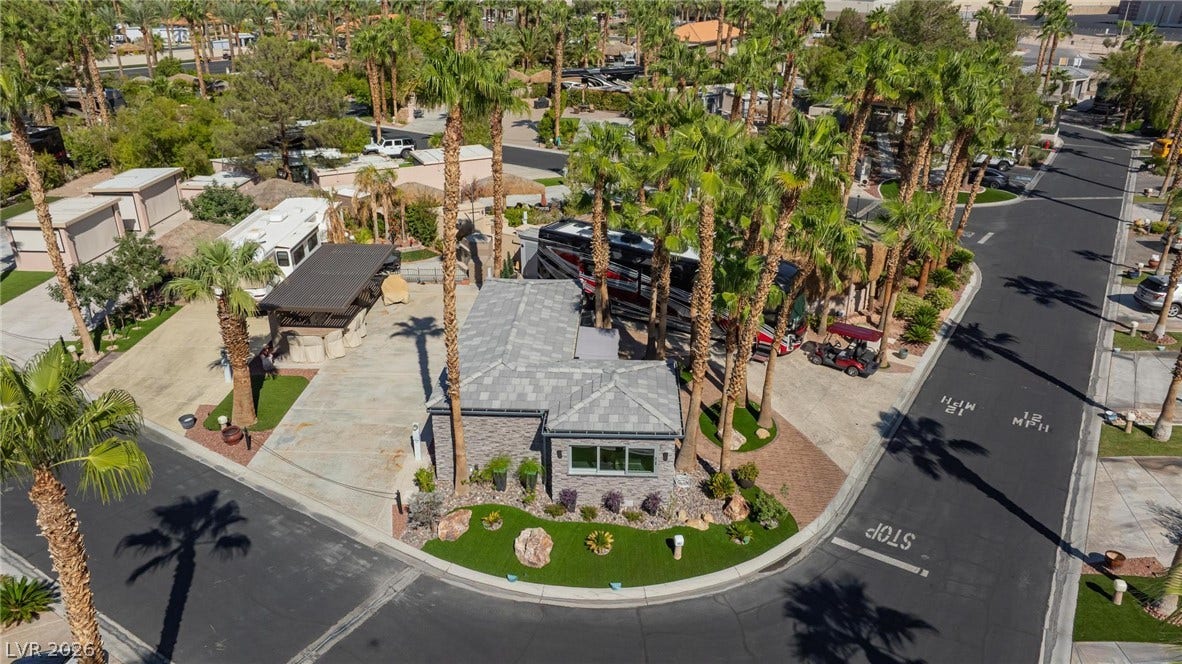8175 Arville Street, #142, Las Vegas, NV 89139 Lush palm trees surround this modern stone-clad exterior with a sleek tiled roof.