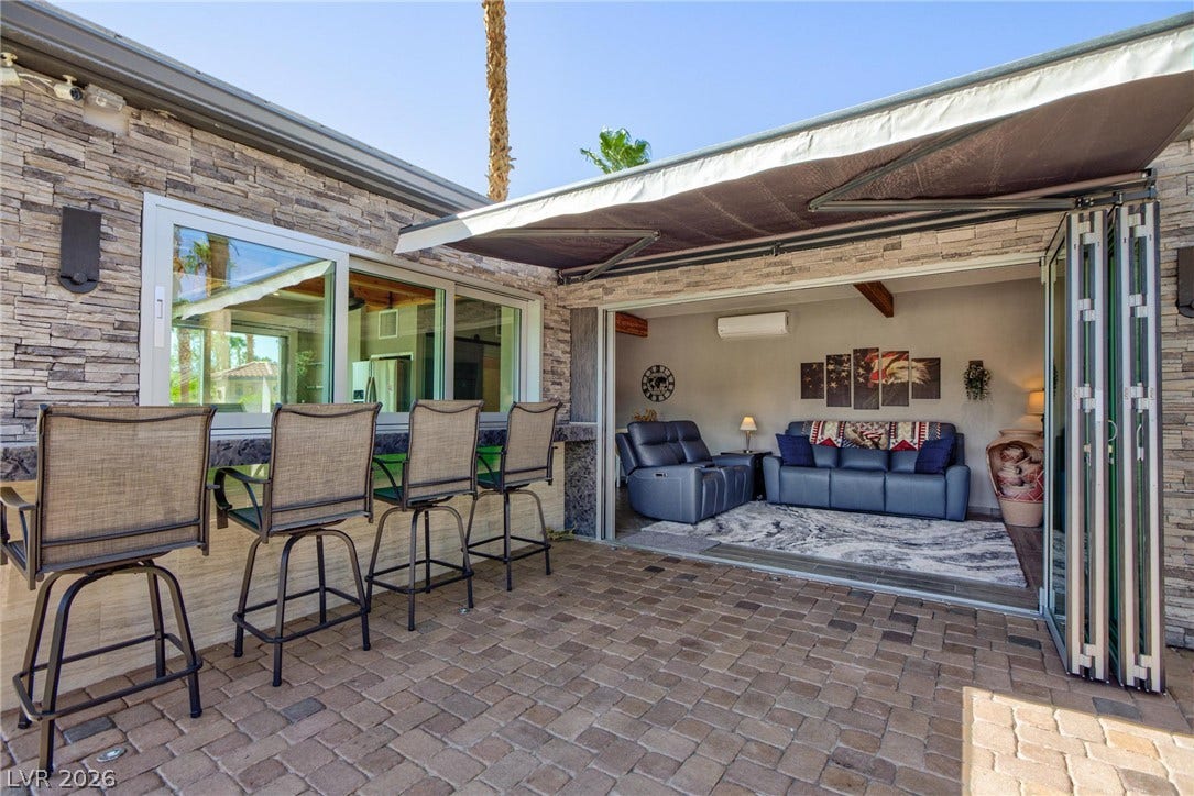 8175 Arville Street, #142, Las Vegas, NV 89139 Stone accents and glass bi-fold doors seamlessly connect the indoor living space to the patio.