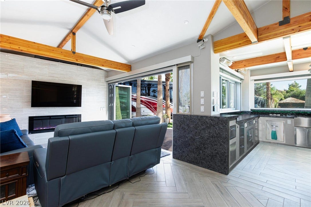 8175 Arville Street, #142, Las Vegas, NV 89139 An open living space highlights vaulted beamed ceilings and sliding glass doors to the outdoors.