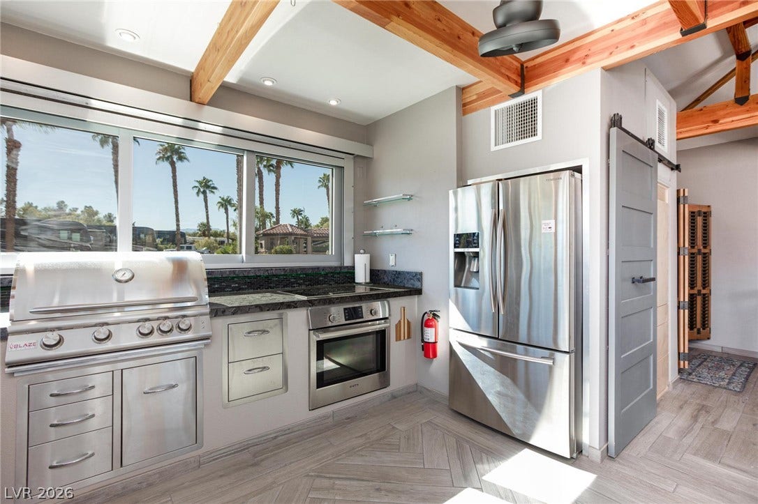 8175 Arville Street, #142, Las Vegas, NV 89139 Exposed wood beams and sleek tiled floors define this contemporary open cooking area.