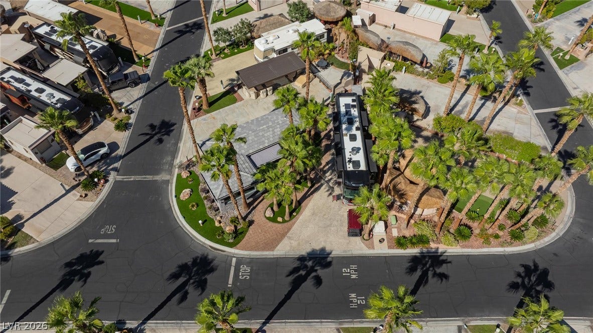 8175 Arville Street, #142, Las Vegas, NV 89139 An aerial perspective showcases a paved lot bordered by mature palm trees and manicured lawns.