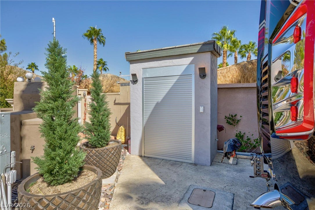 8175 Arville Street, #142, Las Vegas, NV 89139 A stucco storage building with a roll-up metal door stands beside a concrete pad.
