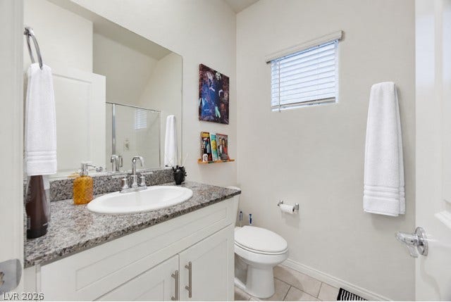 Polished granite countertops and classic tile flooring define this clean half-bath space.